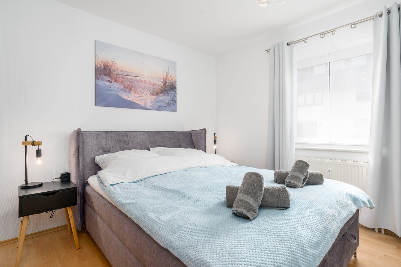 Ferienwohnung Edersee, Schlafzimmer mit Doppelbett und frischen Handtüchern