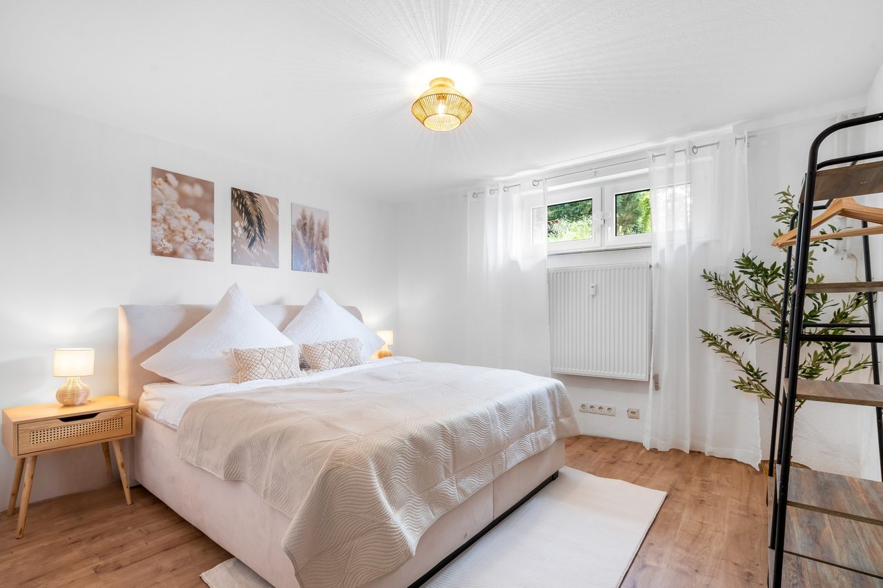 Helles Schlafzimmer mit Doppelbett und Kleiderstange