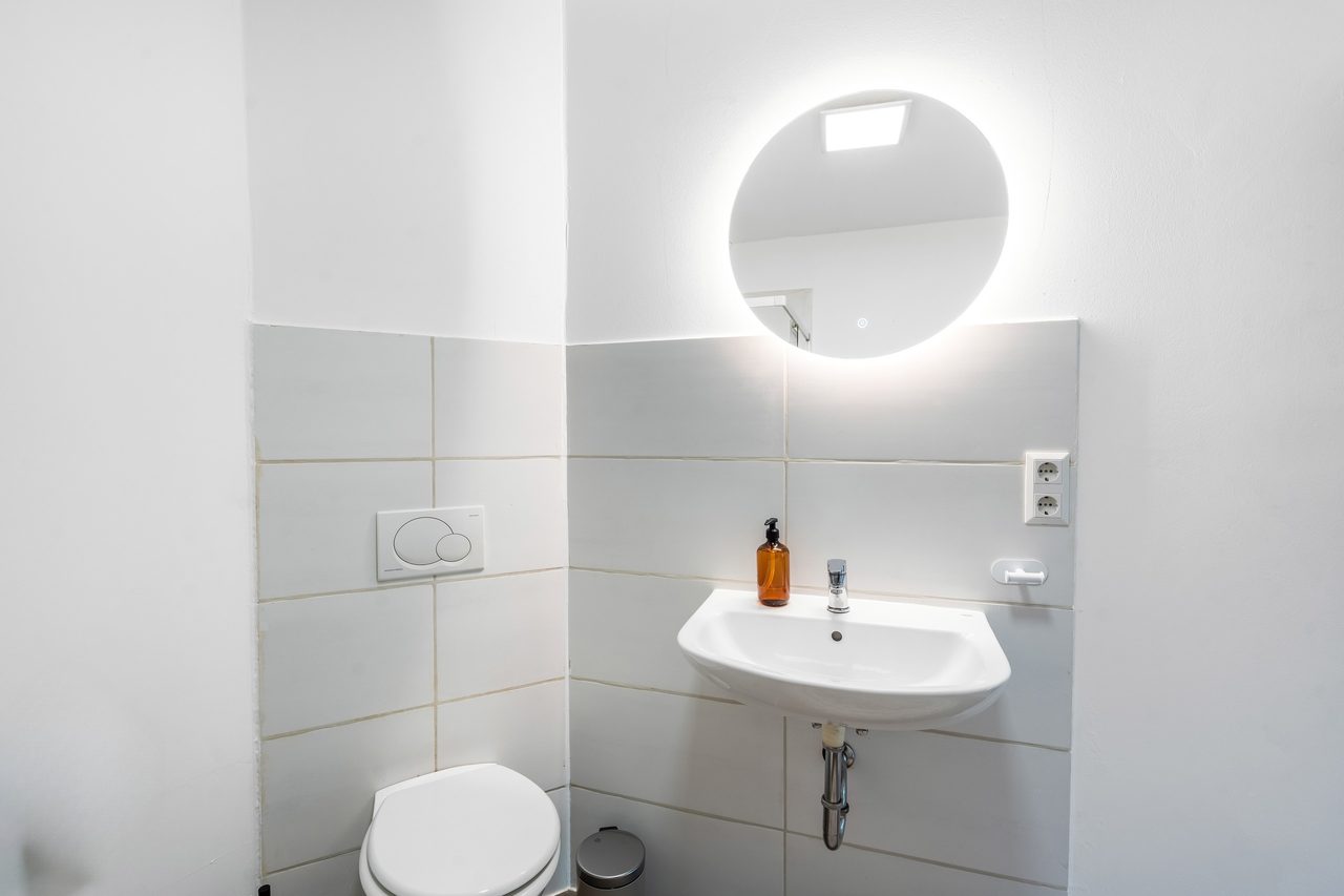 Waschbereich mit rundem LED-Spiegel