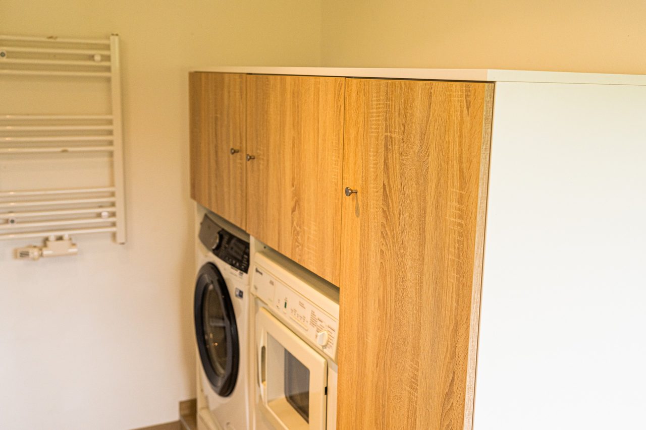 Hauswirtschaftsraum mit Waschmaschine, Trockner und Holzschrank