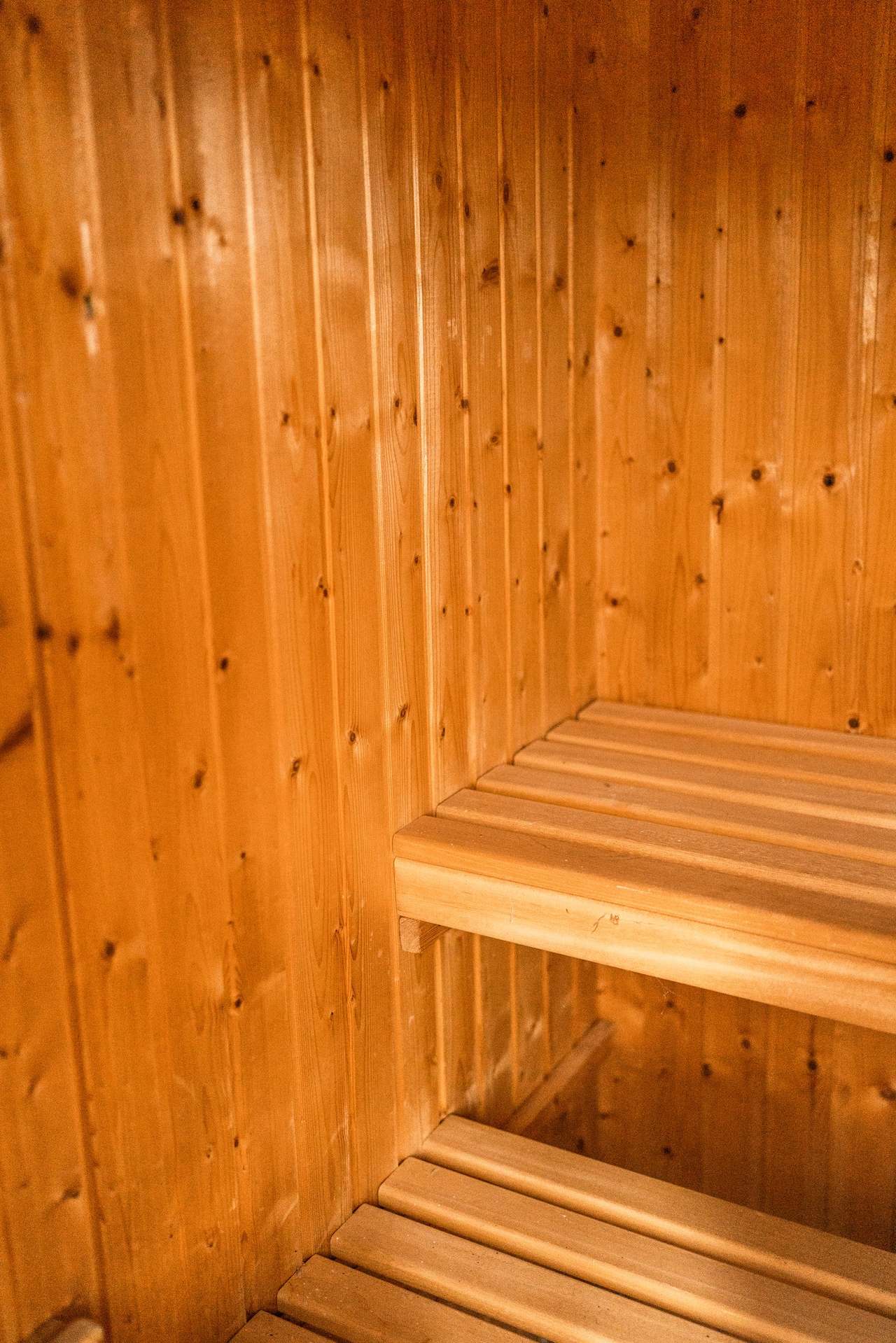 Sauna mit Holzverkleidung und zwei Holzbänken