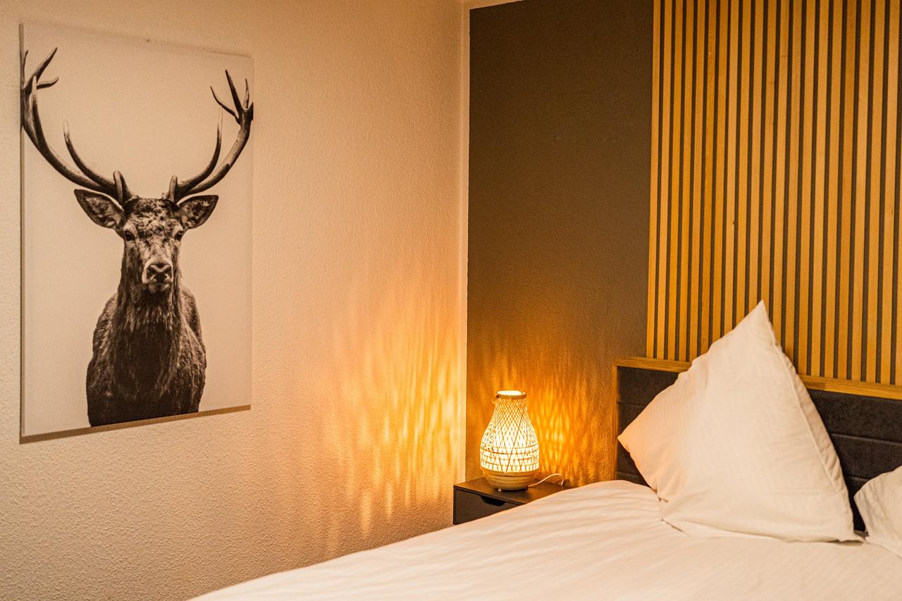 Schlafzimmer mit Doppelbett, Hirschbild und Nachttischlampe