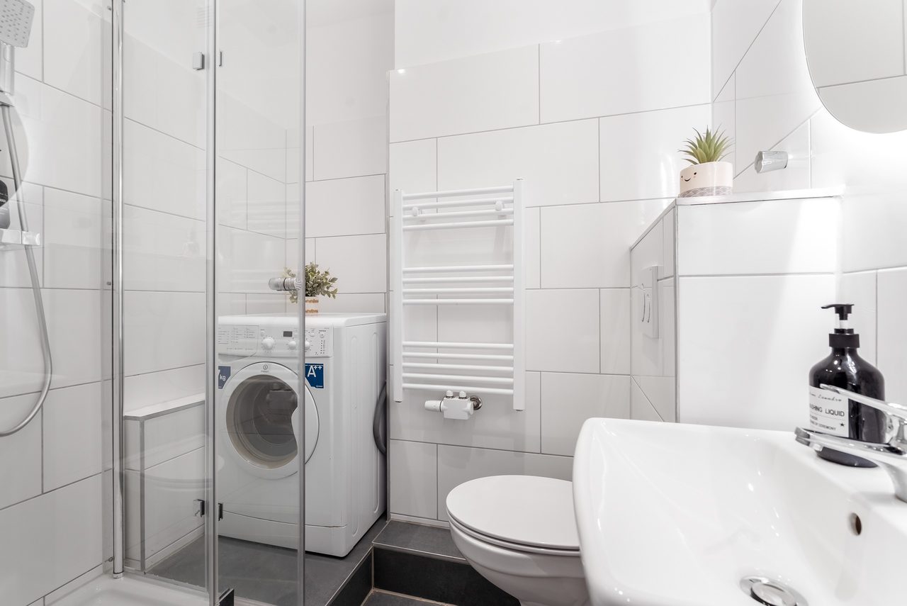 Badezimmer mit Dusche, Waschmaschine, WC und Waschbecken