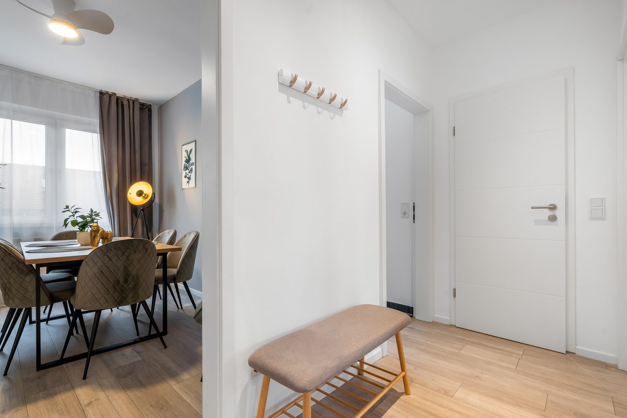 Flur mit Sitzbank, Wandhaken und Blick in den Essbereich