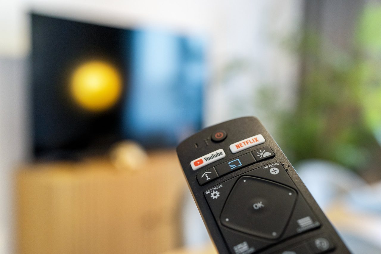 Fernbedienung vor unscharfem Fernseher