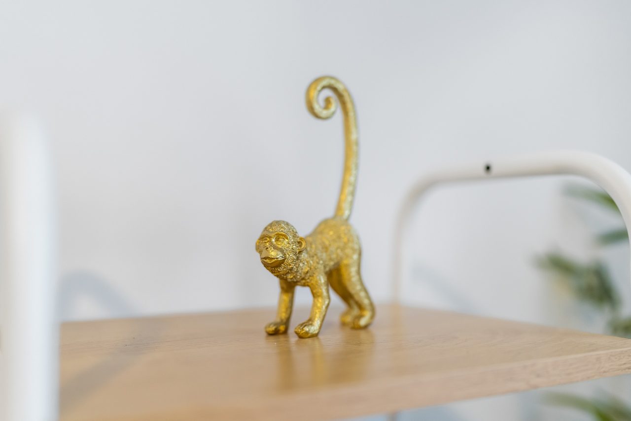 Goldene Affenfigur auf einem Holzregal