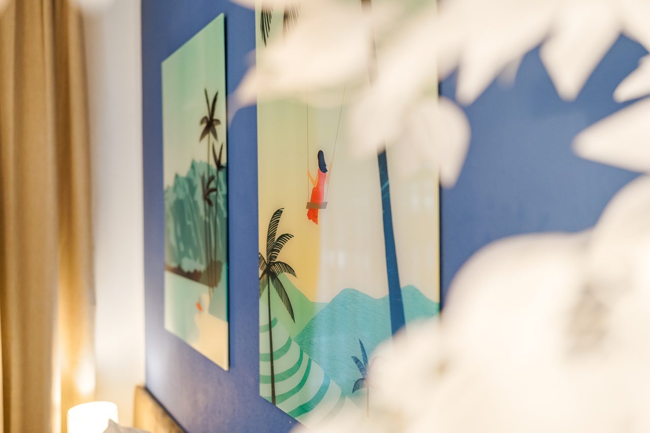 Wandbilder mit Palmenmotiven an blauer Wand