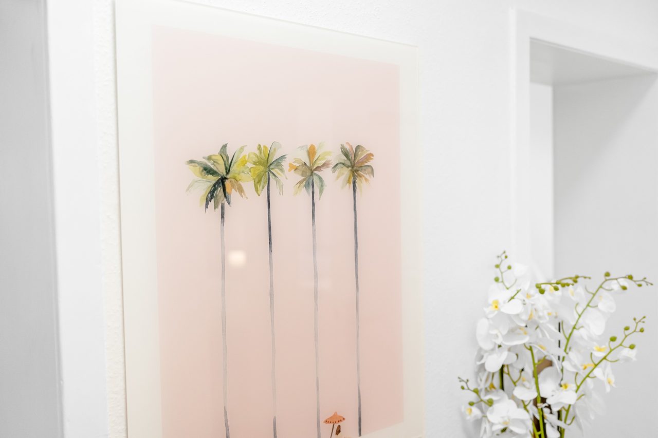 Wandbild mit Palmen neben weißer Orchidee
