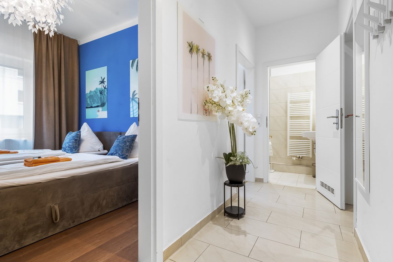Flur mit Orchidee und Blick ins Schlafzimmer und ins Bad