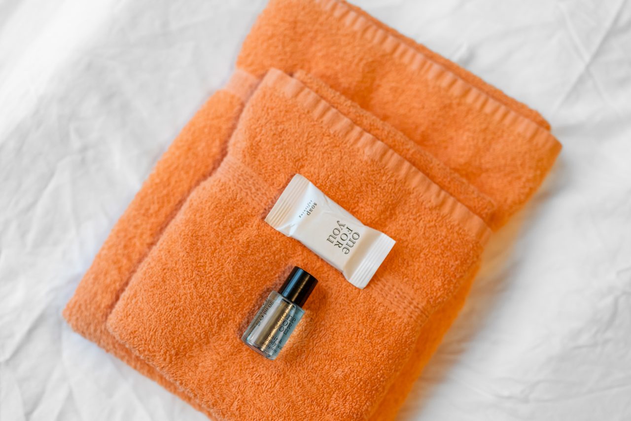 Orange Handtücher mit Seife und kleinem Pflegefläschchen