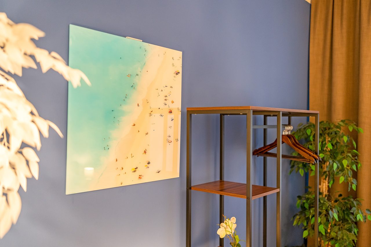 Wandbild mit Strand an grauer Wand neben Kleiderregal