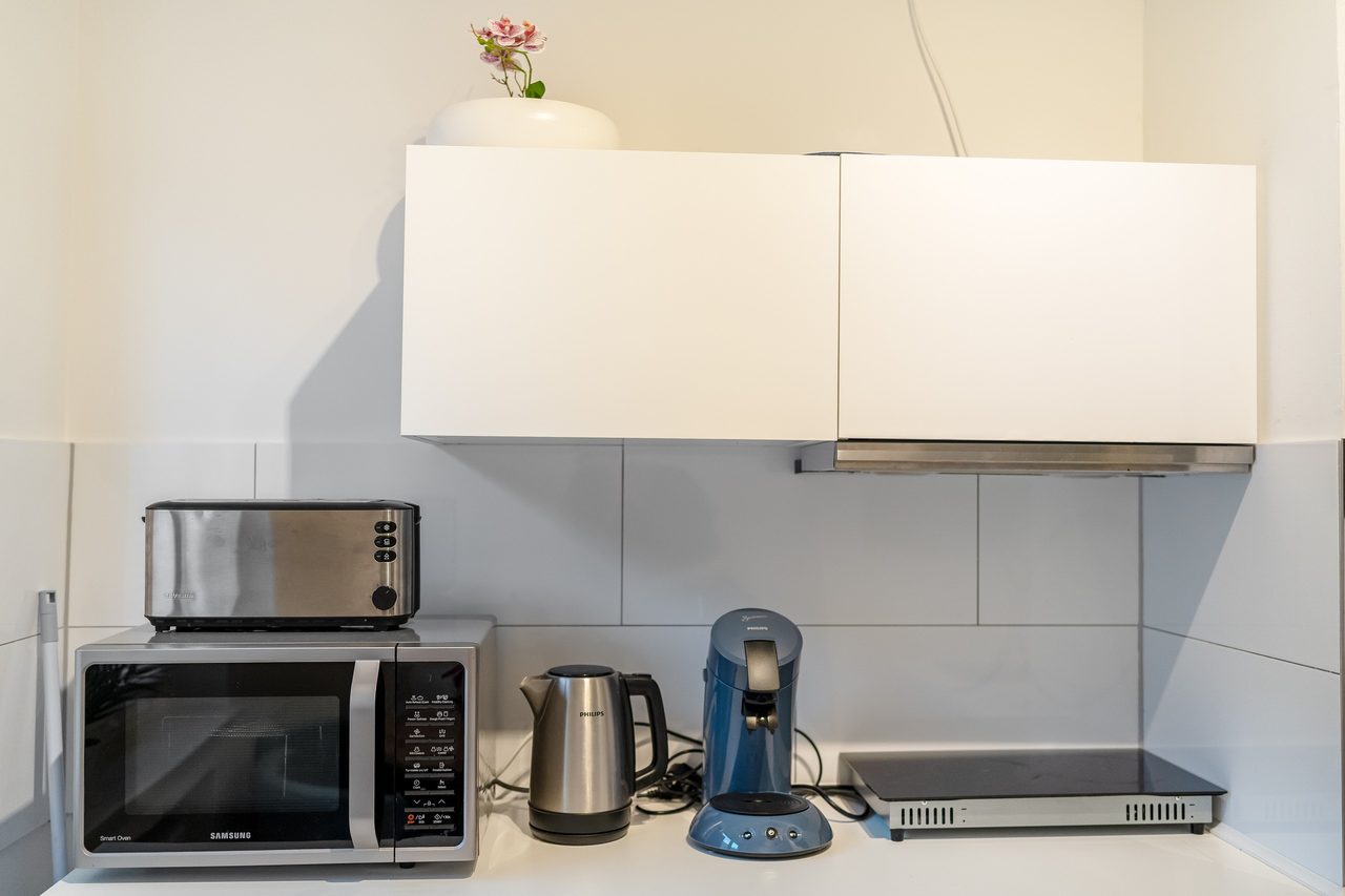 Küchenzeile mit Toaster, Mikrowelle, Wasserkocher und Kaffeemaschine