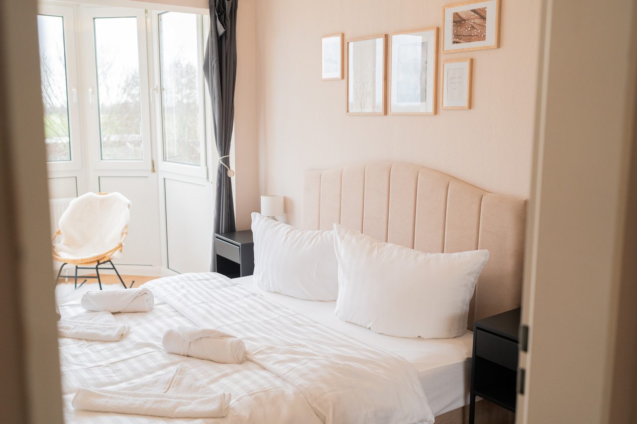Ferienwohnung Nordseeküste Cuxhaven, helles Schlafzimmer mit Doppelbett, Bild 7
