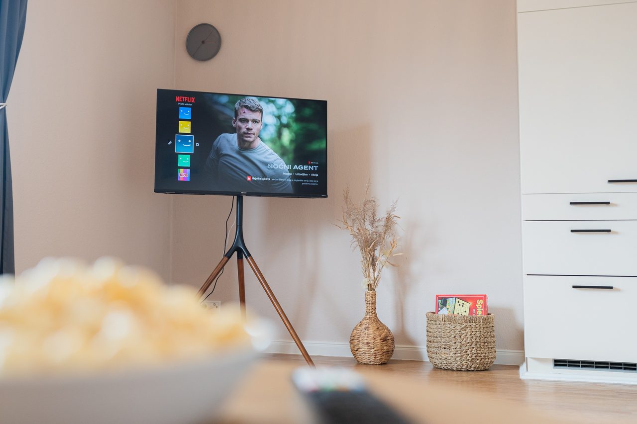 Fernseher auf Dreibeinständer mit Popcornschüssel im Vordergrund