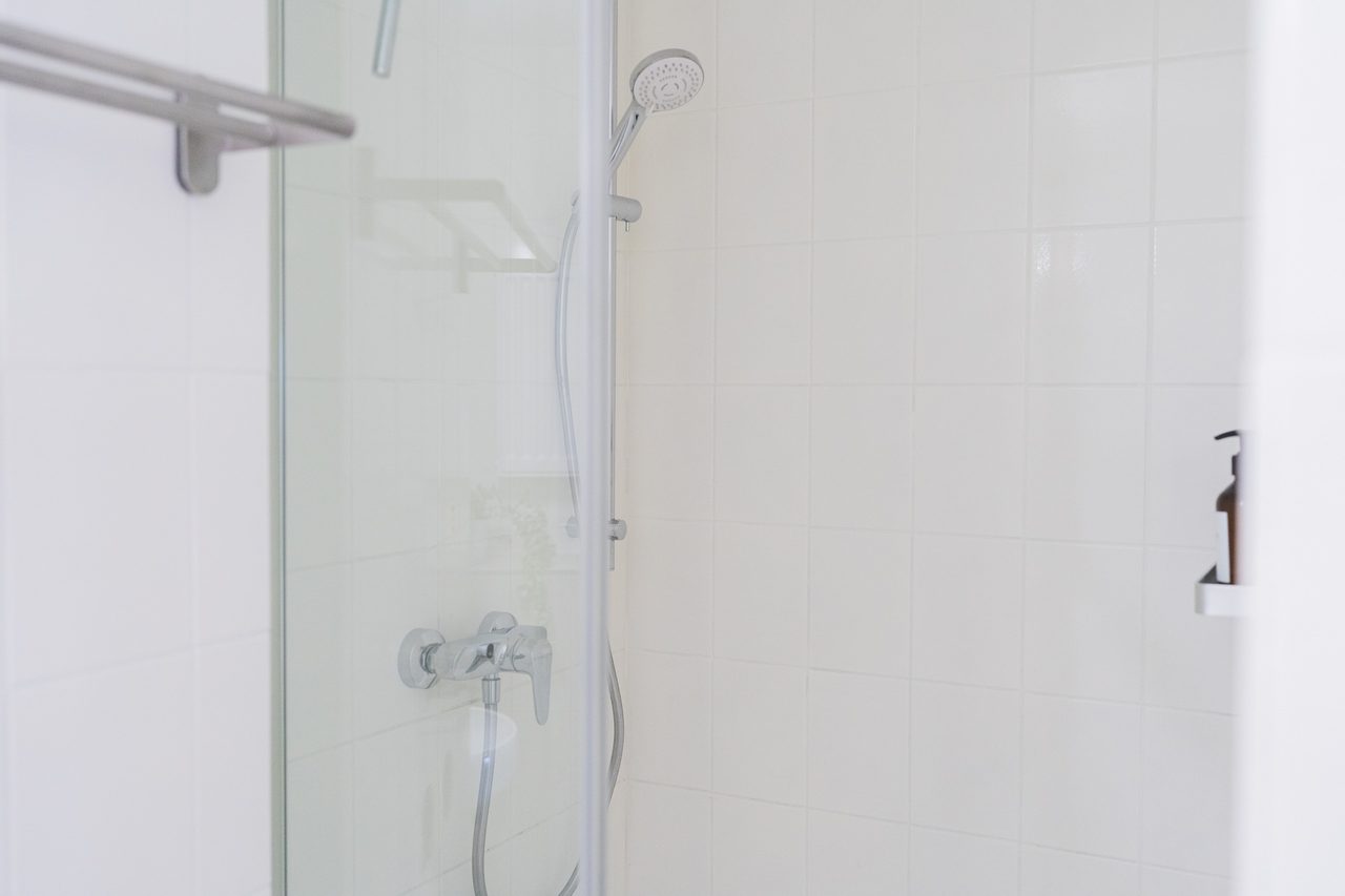 Dusche mit Glaswand, Handbrause und Armatur