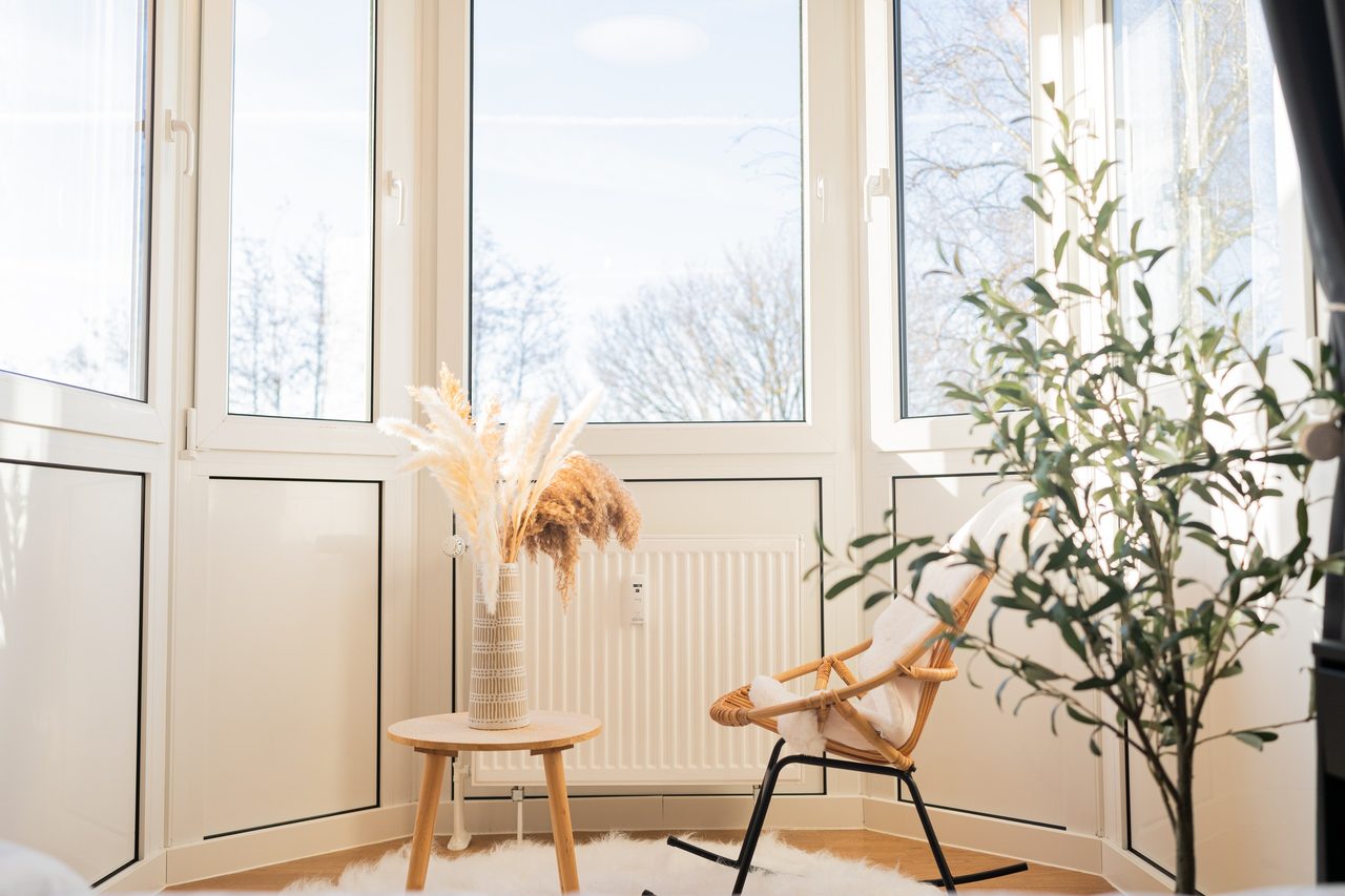 Erker mit Rattansessel, Beistelltisch und Olivenbäumchen