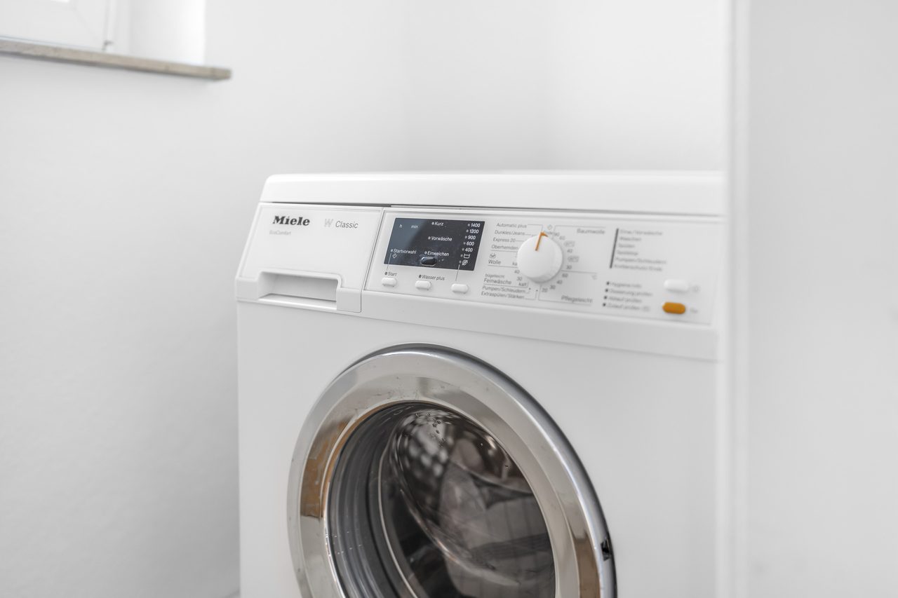 Weiße Waschmaschine mit Frontlader in einem hellen Raum