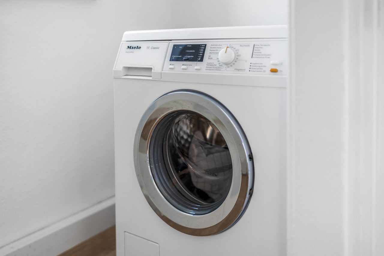 Weiße Waschmaschine mit Frontlader in einer weißen Nische