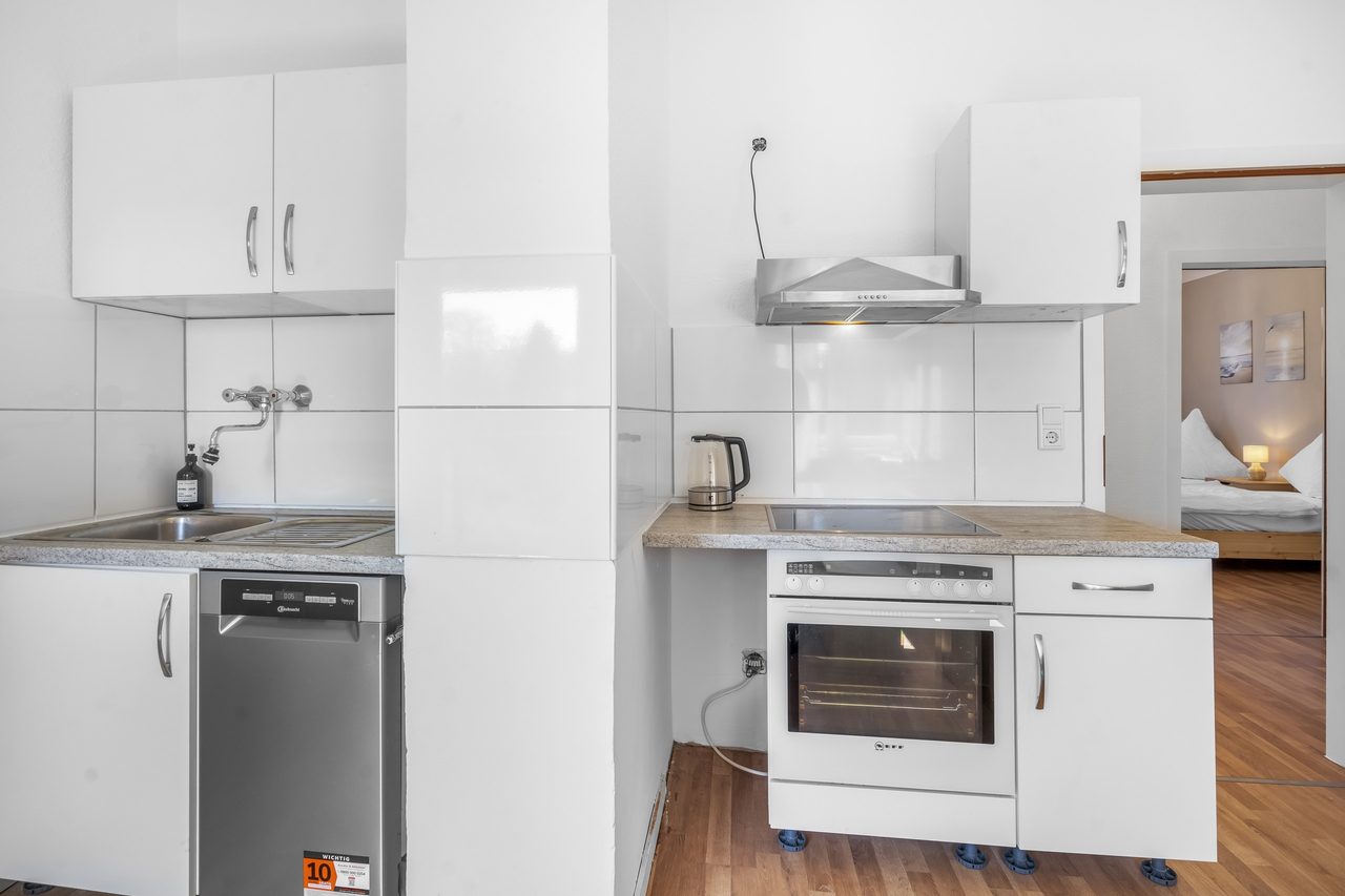 Küchenzeile mit Spüle, Backofen, Geschirrspüler und Wasserkocher