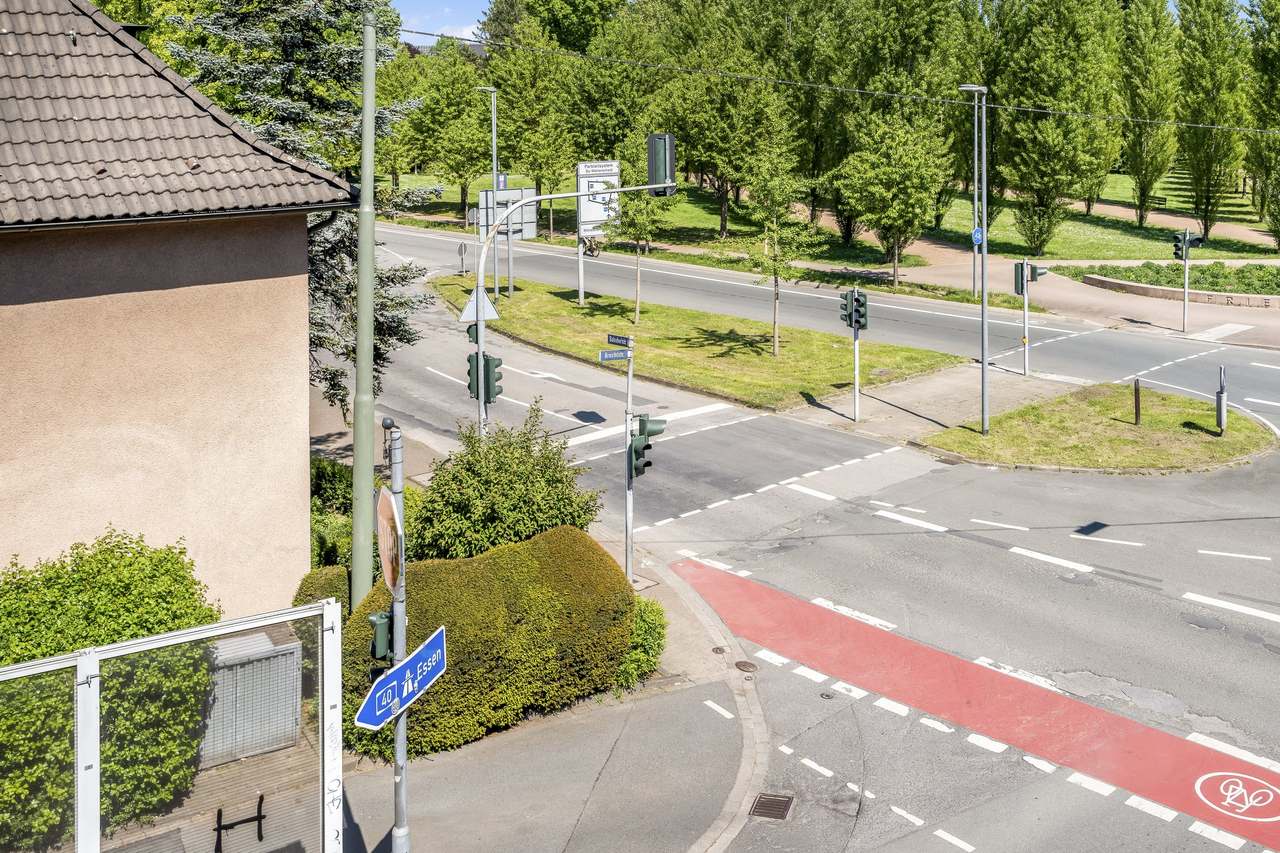 Blick vom Balkon auf eine Straßenkreuzung mit Bäumen