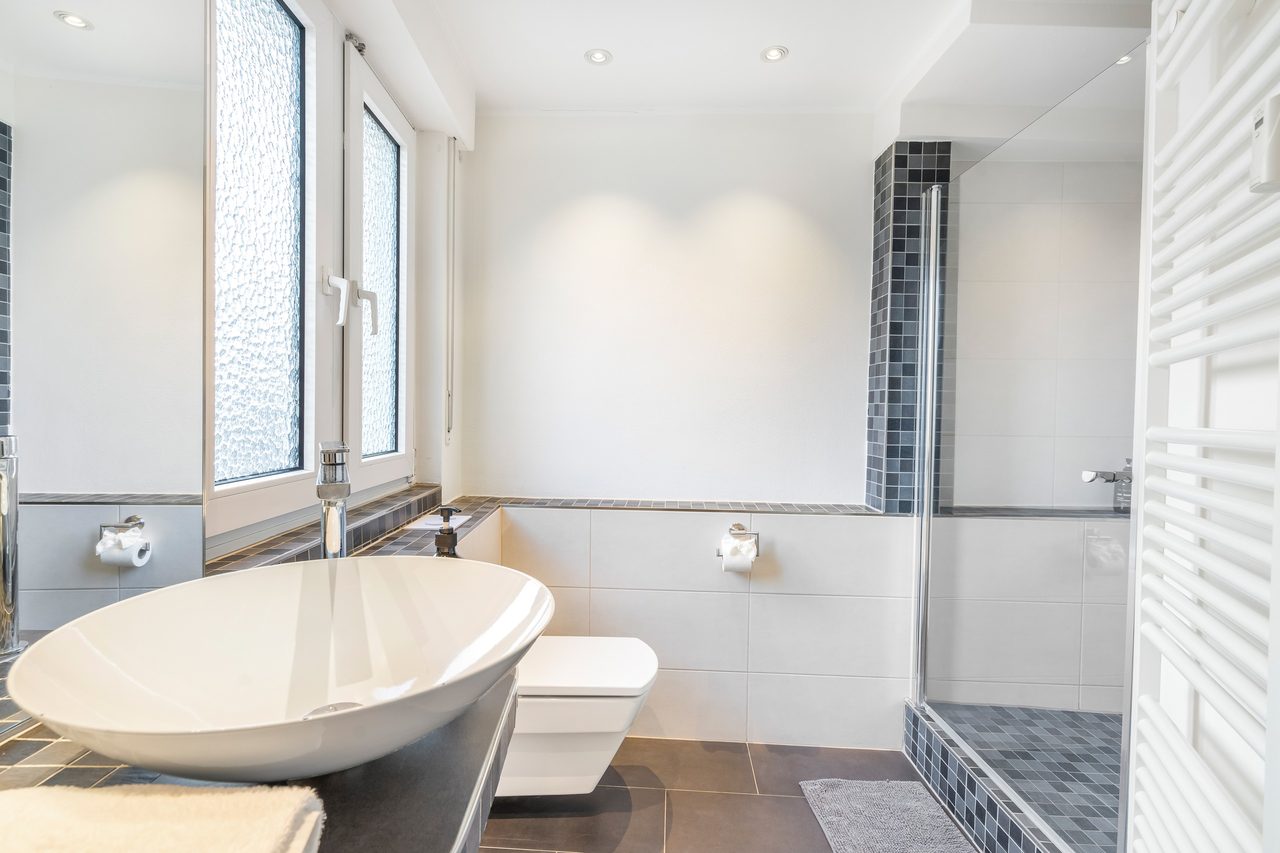 Badezimmer mit Aufsatzwaschbecken, Wand-WC und bodengleicher Dusche