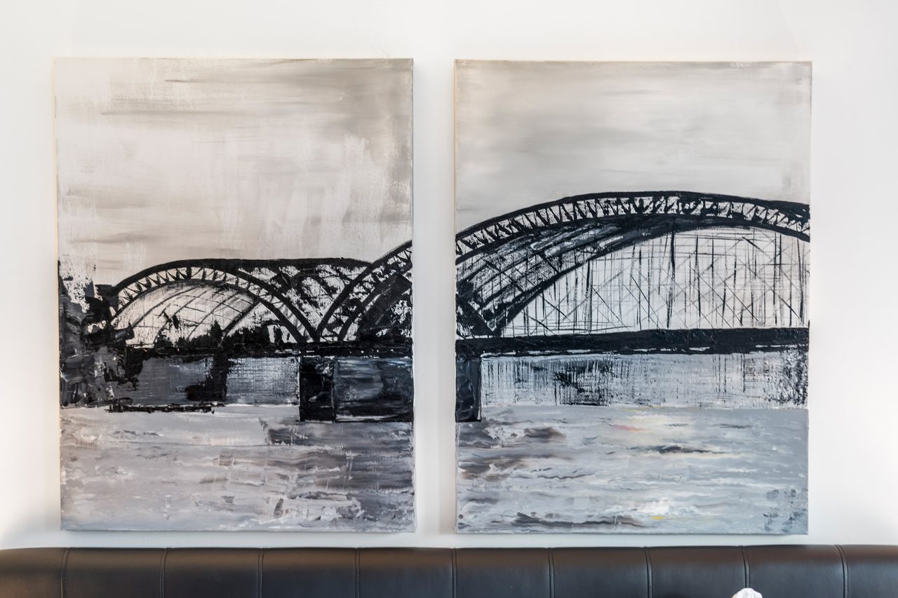 Zwei Wandbilder mit schwarzweißer Bogenbrücke über dem Fluss