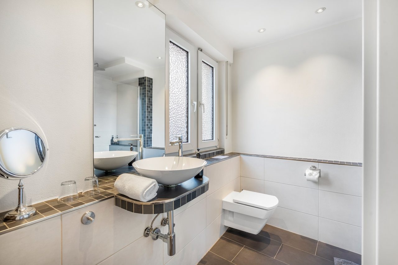 Badezimmer mit Aufsatzwaschbecken, Handtüchern und Wand-WC