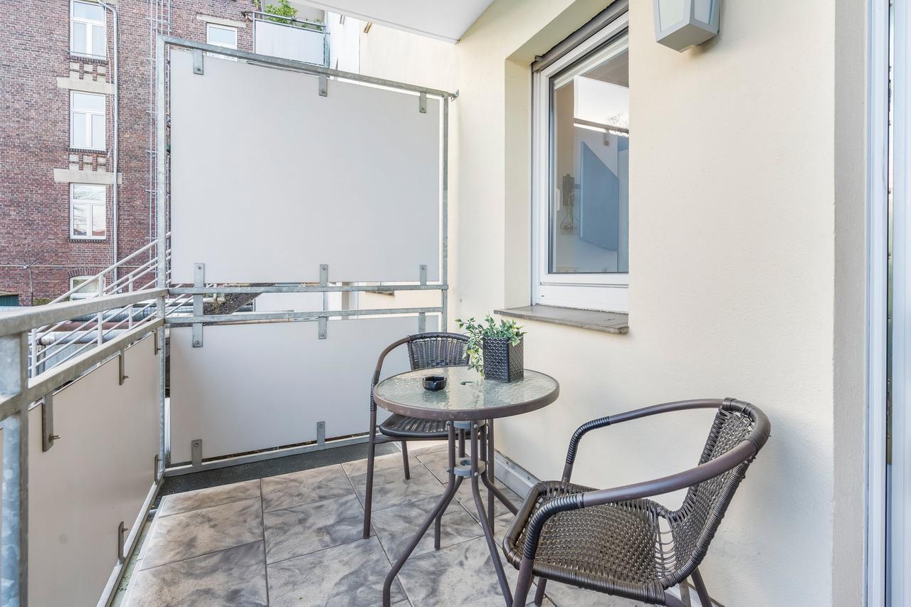 Balkon mit Bistrotisch, zwei Rattanstühlen und Sichtschutzwand