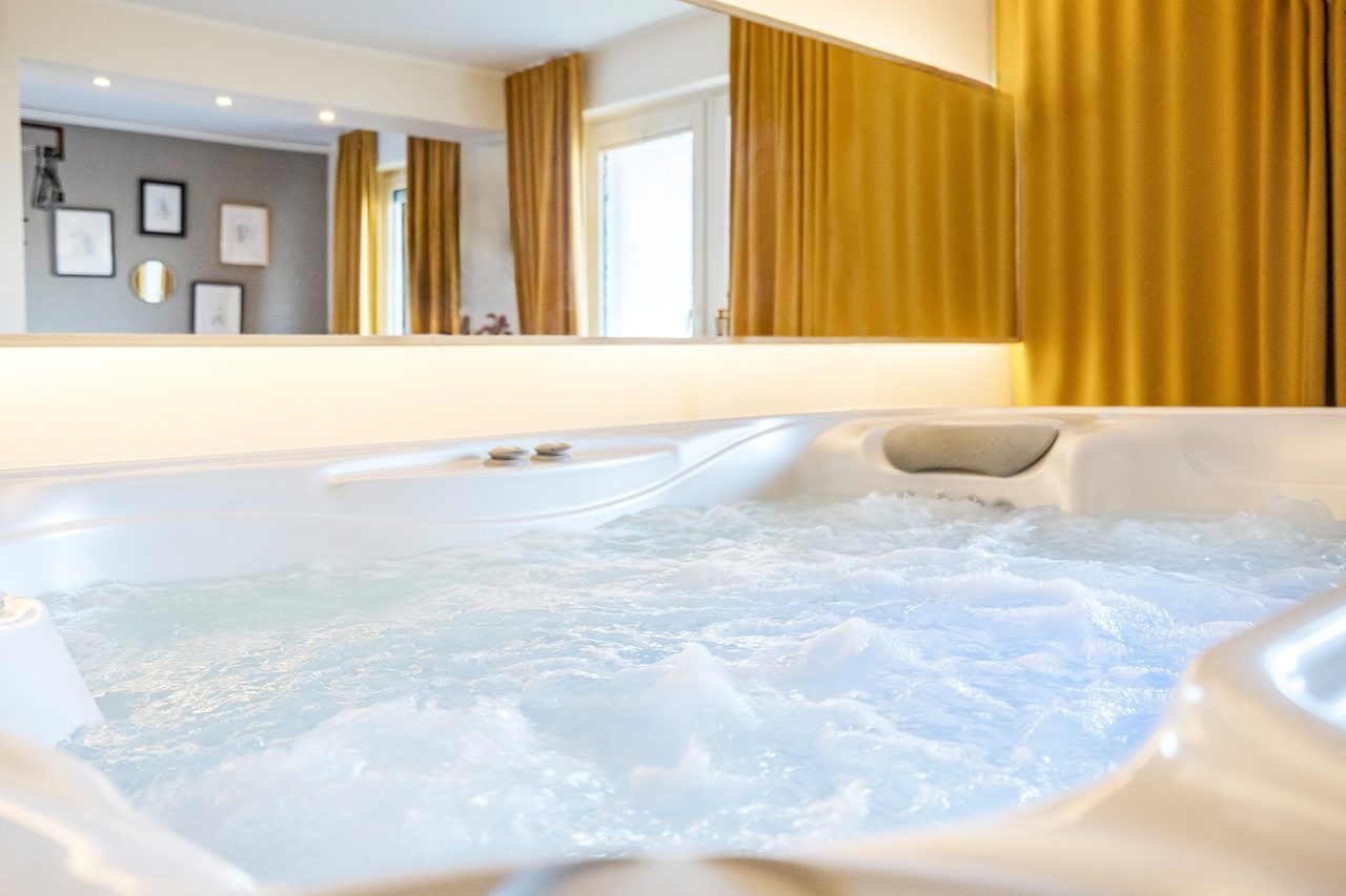 Sprudelnder Whirlpool mit Wasser vor goldfarbenen Vorhängen