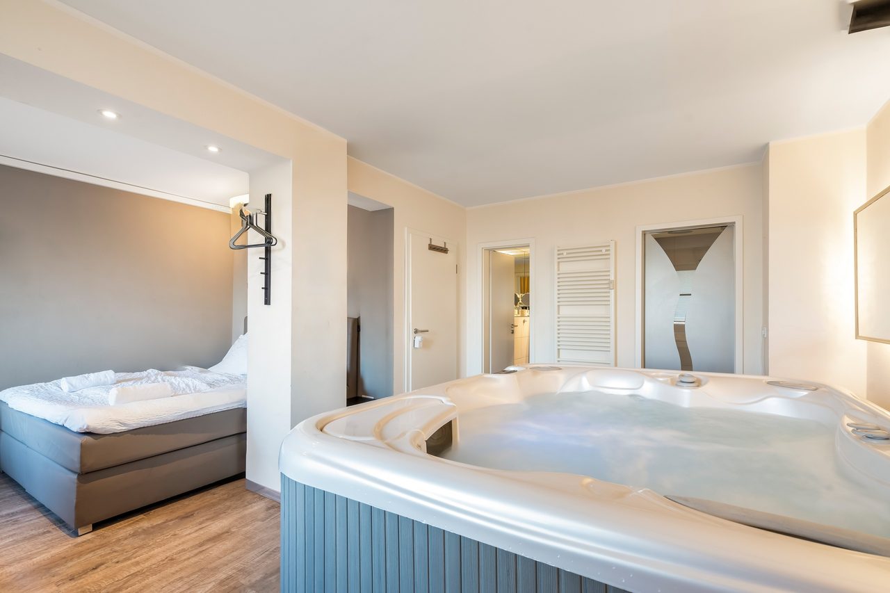 Zimmer mit Whirlpool, Doppelbett und Wandgarderobe