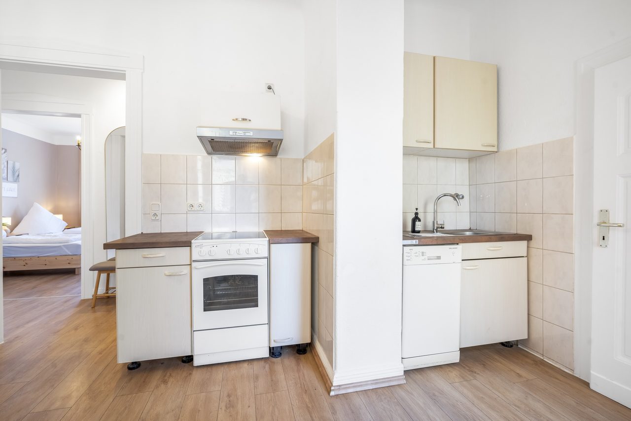 Küche mit Herd, Spüle und Blick ins Schlafzimmer