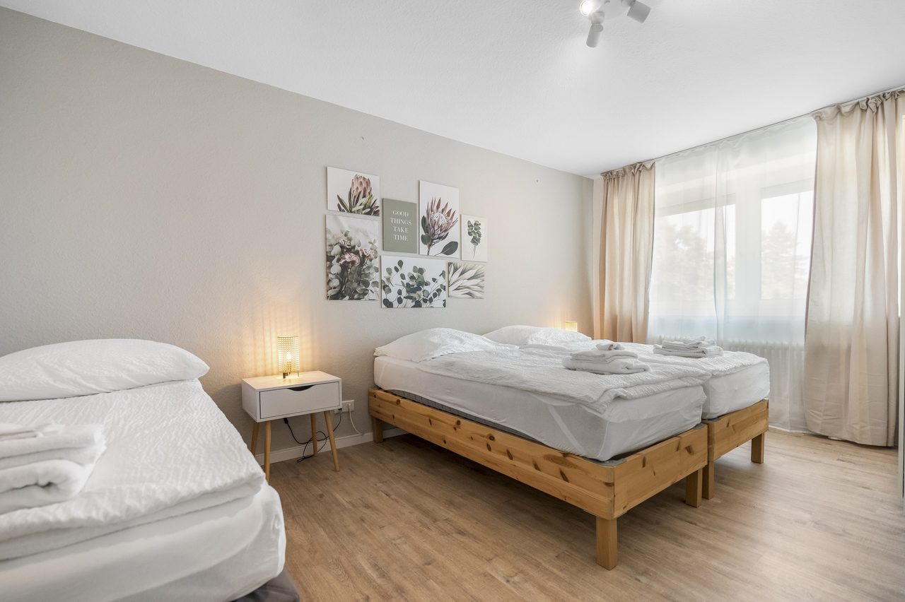 Schlafzimmer mit zwei Einzelbetten aus Holz und Handtüchern