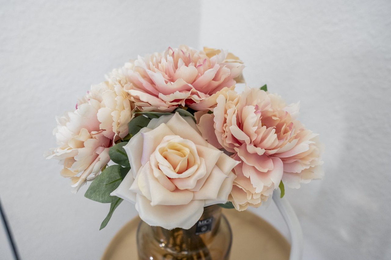 Strauß mit rosa Kunstblumen in einer Vase